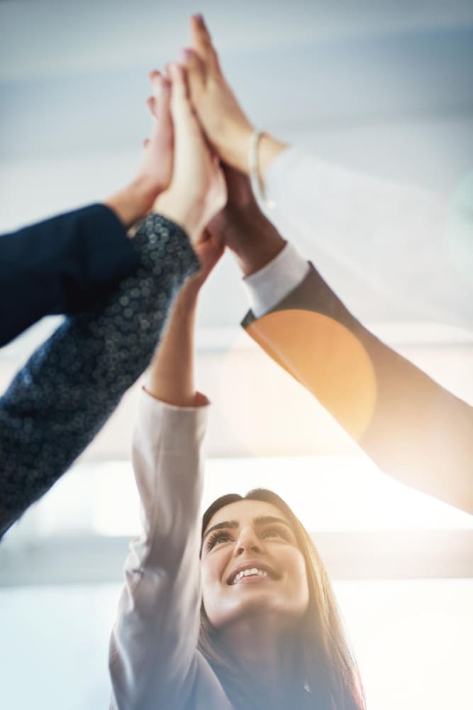 Un grupo de personas chocando la mano como un equipo.